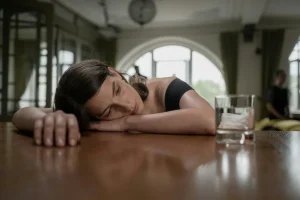 Mujer cansada y pensativa en la cocina reflejando agotamiento emocional y diálogo interno exigente.
